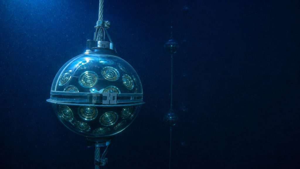 Glazen sensorbol van neutrinotelescoop KM3NeT aan een kabel diep onder water